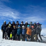 JHSC Alpine ski team taking a group photo on the snow